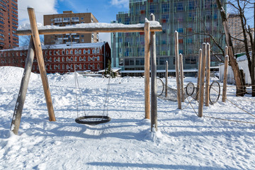 Snow-covered children's playground in public park in winter
