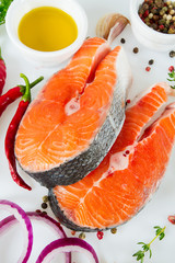 pieces of salmon and herbs over white