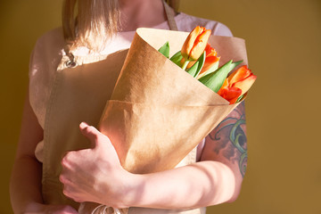 Florist holding a gift bouquet of tulips