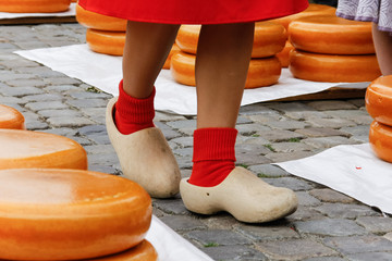 Young woman legs in wooden dutch klomp shoes on a old town market in Gouda, Holland - obrazy, fototapety, plakaty