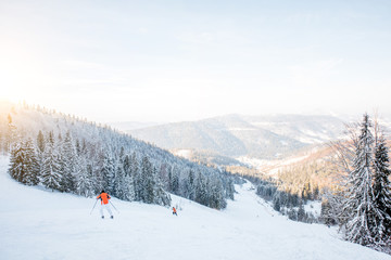 Landscape view on the beautiful Carpathian mountains with ski slope and skiers during the sunny weather