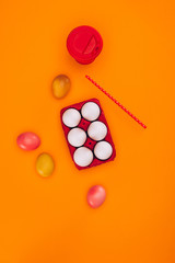 top view of chicken eggs in red egg tray and coffee isolated on orange