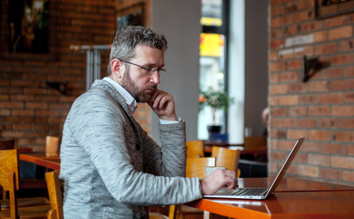 Middle age man using laptop in the cafe