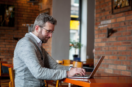 Middle Age Man Using Laptop In The Cafe