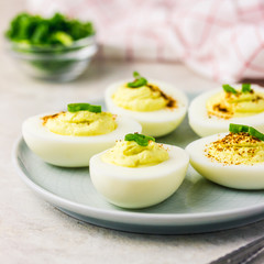 Healthy deviled eggs with paprika and chives on white background. Selective focus ,space for text.