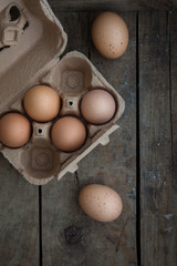 Frische Eier in einer Eierpackung auf einem alten dunklen Holzuntergrund