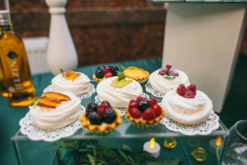 Delicious cookies, marshmallows, macarons and other sweets served on dinner table