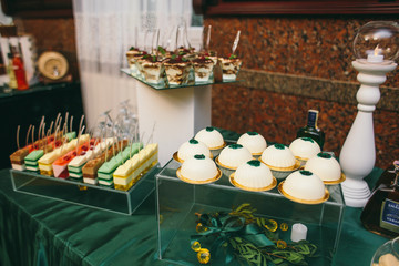 Delicious cookies, marshmallows, macarons and other sweets served on dinner table