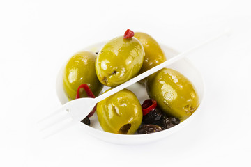 Olives in a small plastic plate on a white background. 