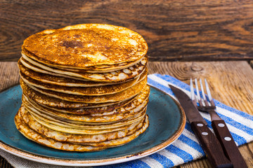 High stack of hot pancakes on wooden table