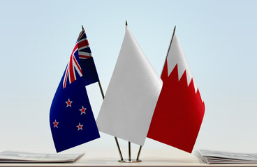 Flags of New Zealand and Bahrain with a white flag in the middle