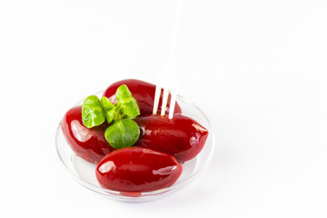 Olives in a small plastic plate on a white background. 