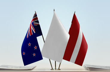 Flags of New Zealand and Latvia with a white flag in the middle