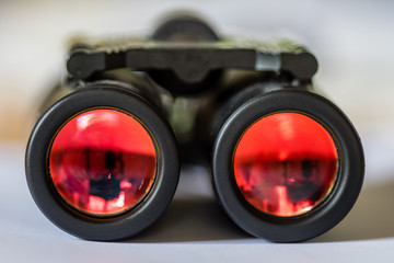 Closeup of a binocular with red colored glass