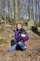 frau hält ihren hund auf dem arm