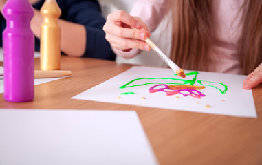 Children painting on paper at home close up