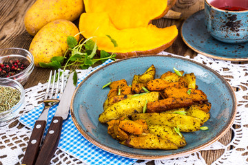Baked vegetables, potatoes and pumpkin with herbs and spices