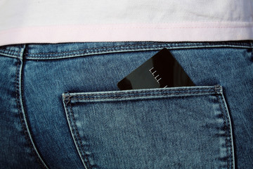 Credit card in pocket blue denim jean for business, shopping and finance concept. women hand take...