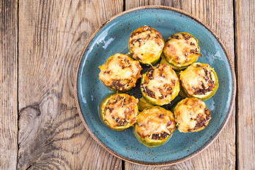 Zucchini stuffed with meat and cheese on blue plate