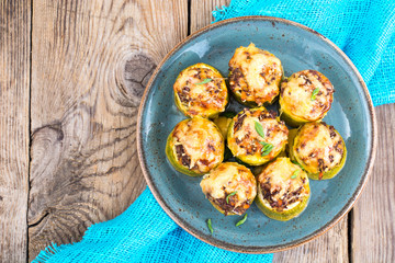 Zucchini stuffed with meat and cheese on blue plate