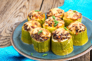 Zucchini stuffed with meat and cheese on blue plate