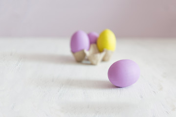 Easter postcard. Violet and yellow Easter eggs on a white vintage background. Copy space.