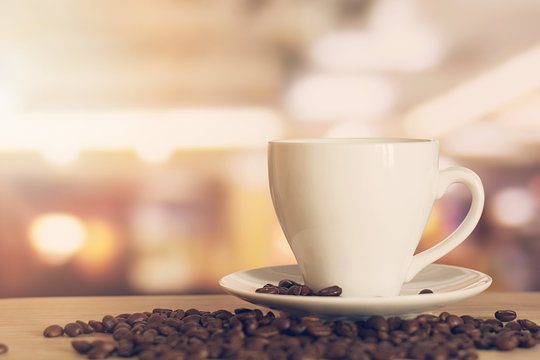 cup of coffee on wooden table with defocus bokeh of coffee shop background. Image with soft focus and blurred background.