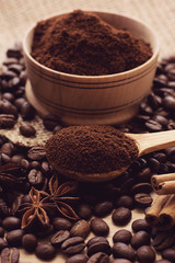 Coffee beans and ground coffee in a wooden spoon.