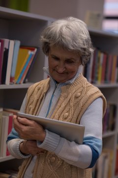Senior woman using digital tablet in library
