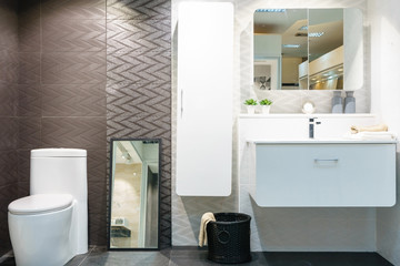 Modern spacious bathroom with bright tiles with toilet and sink. Side view