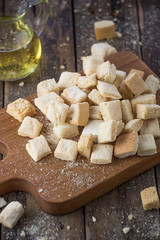 homemade croutons from white bread in wood on old wood table

