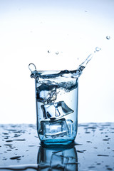 splash of water in glass Cup with ice slice on white background close-up