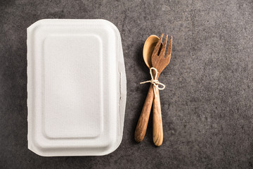 paper box for takeaway with spoon and fork wood on old marble background

