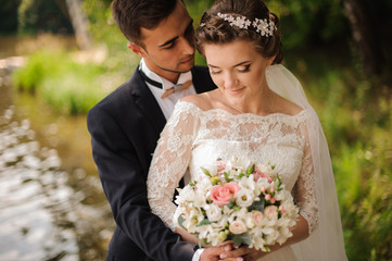 Portrait of a bridegroom embracing a bride