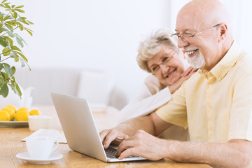 Smiling elderly man searching informations