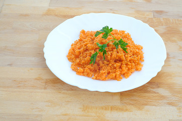 minced orange carrot and parsley in a dish