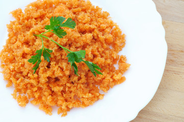 close up minced orange carrot and green parsley in a dish, from above