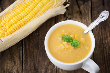 Corn soup in bowl and sweet corn on plate


