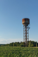Water tower, sunlight and against a cloudy sky at dusk.