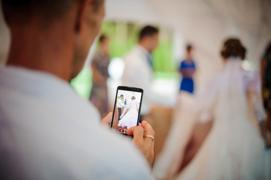 Back view of man recording a video on the wedding party