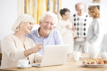 Fototapeta na wymiar Elder couple sitting at laptop