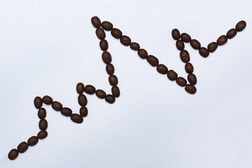 A line of electrocardiograms of roasted coffee beans on white background, heart rhythm ecg,...