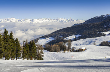 Fototapeta na wymiar Panoramic view of wide and groomed ski piste in resort of Pila in Valle d'Aosta, Italy during winter