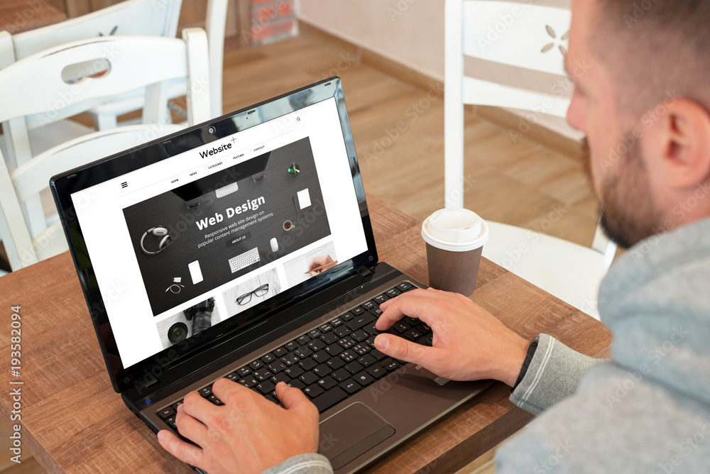 Poster web design company responsive web site on laptop display. guy watch site and drink coffee.