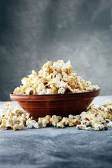 Salt popcorn or sweet popcorn on old grey background.