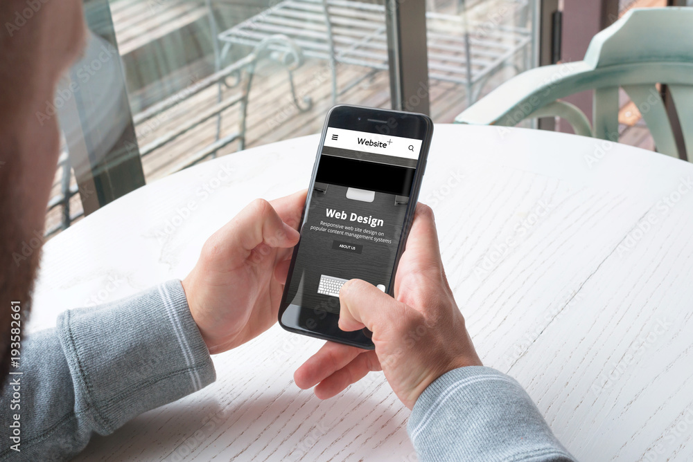 Aufkleber Responsive web site od design company on mobile phone in man hands.