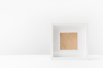 close-up view of empty white photo frame on white