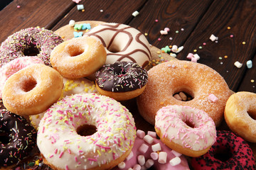 assorted donuts with chocolate frosted, pink glazed and sprinkles donuts.