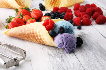 Set of ice cream scoops of different colors and flavours with blueberries, raspberries and blackberries.