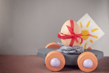 Easter egg on a toy car as a symbol of the arrival of spring